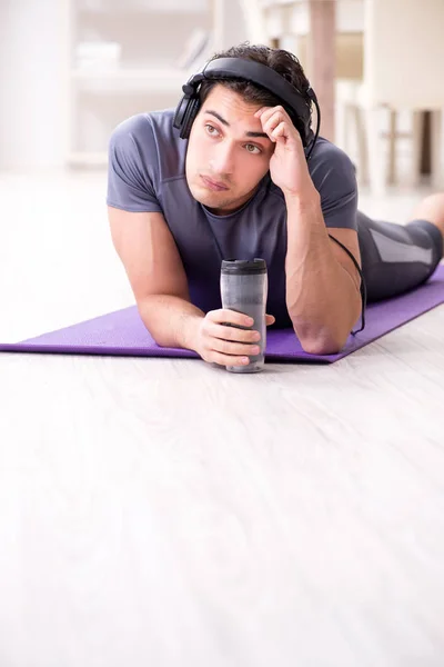 Man doing sports at home and listening to music