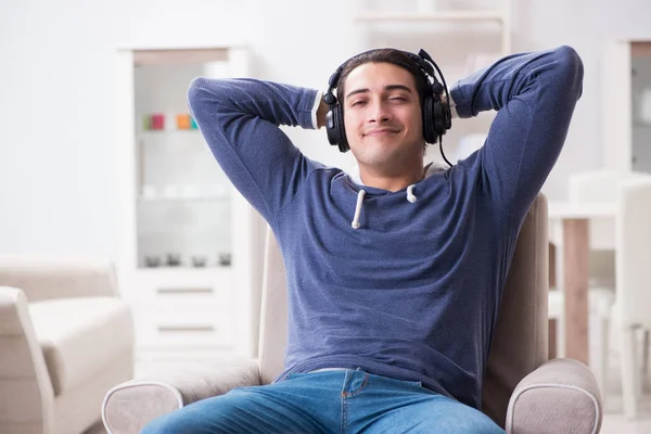 Jongeman die thuis naar muziek luistert — Stockfoto