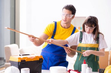 Ahşap atölyesinde kadın marangozluk ipuçlarını açıklayan adam