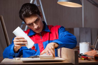 Genç adam ahşap parçaları DIY konseptinde yapıştırıyor.