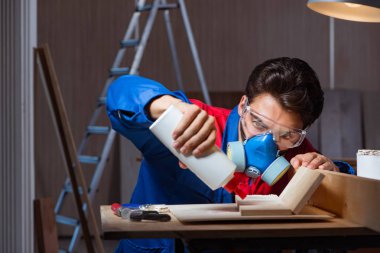 Genç adam ahşap parçaları DIY konseptinde yapıştırıyor.