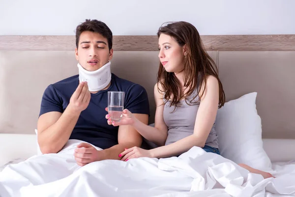 Loving wife taking care of injured husband in bed — Stock Photo, Image