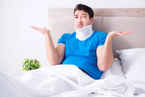 Mladý muž se zraněním krku v posteli — Stock fotografie
