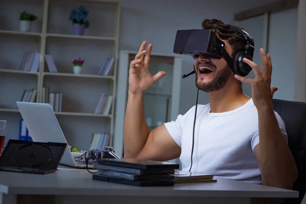 Jovem jogando jogos longas horas atrasado no escritório — Fotografia de Stock