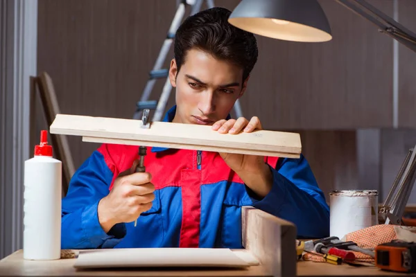 Genç adam ahşap parçaları DIY konseptinde yapıştırıyor.