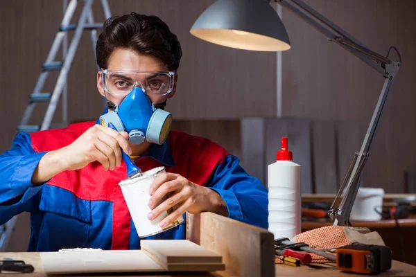 Junger Mann klebt Holzteile in DIY-Konzept zusammen — Stockfoto