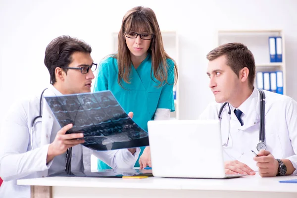 Tre läkare diskuterar skanningsresultat av röntgenbild — Stockfoto
