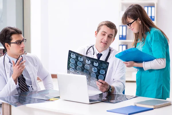 Tre medici discutono i risultati della scansione dell'immagine a raggi X — Foto Stock