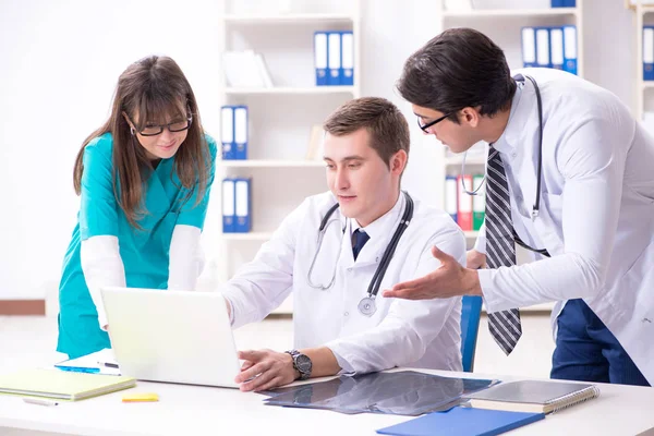 Tres médicos discutiendo los resultados de la exploración de la imagen de rayos X — Foto de Stock