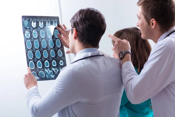 Three doctors discussing scan results of x-ray image — Stock Photo, Image