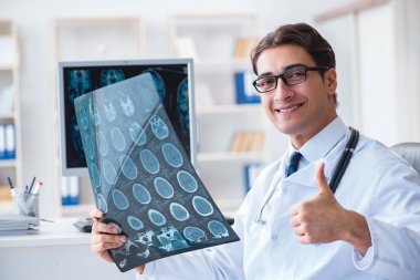 Doktor radyoloji uzmanı röntgen görüntülerine bakıyor.