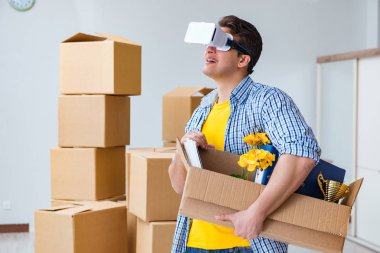 Young man wearing VR glasses moving in new apartment clipart