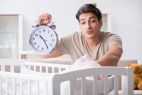 갓난아기 침대 근처에서 시계를 차고 있는 어린 아버지 — 스톡 사진