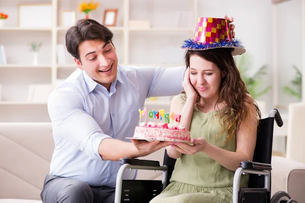 Joven familia celebrando cumpleaños con persona discapacitada —  Fotos de Stock