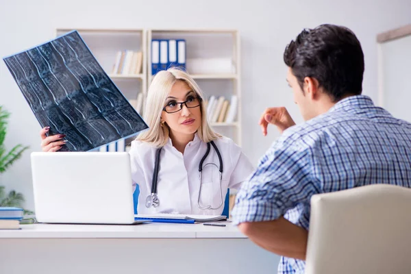 Läkare undersöker röntgenbilder av patienten — Stockfoto