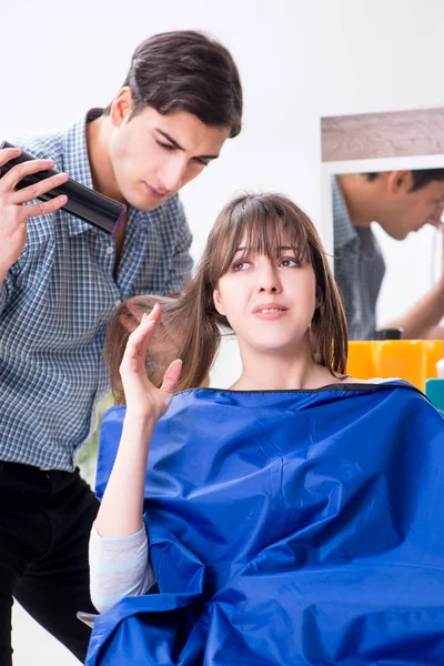 Man male hairdresser doing haircut for woman