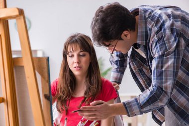 Stüdyoda resim sınıfında sanatçı koçluğu yapan bir öğrenci.