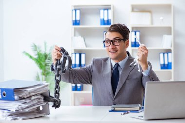 Ofis masasına zincirlenmiş meşgul bir çalışan.