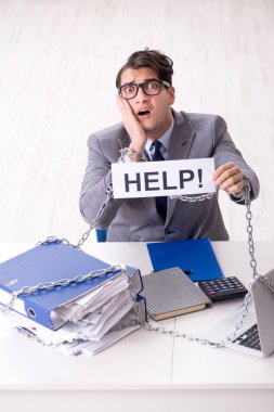 Ofis masasına zincirlenmiş meşgul bir çalışan.