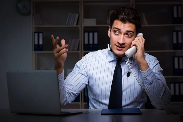 Operador de call center conversando com o cliente durante o turno da noite — Fotografia de Stock