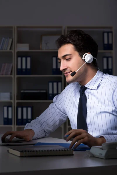 Call center operator talking to customer during night shift — Stock Photo, Image