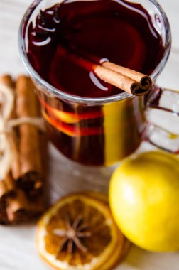 Haşlanmış şarap, yılbaşı masasında servis edilen bardaklarda parlıyor.