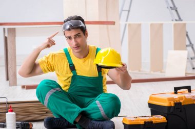 Müteahhit atölyesinde sarı şapka takan marangoz.