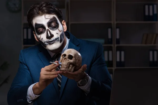 Empresário com máscara facial assustadora trabalhando até tarde no escritório — Fotografia de Stock