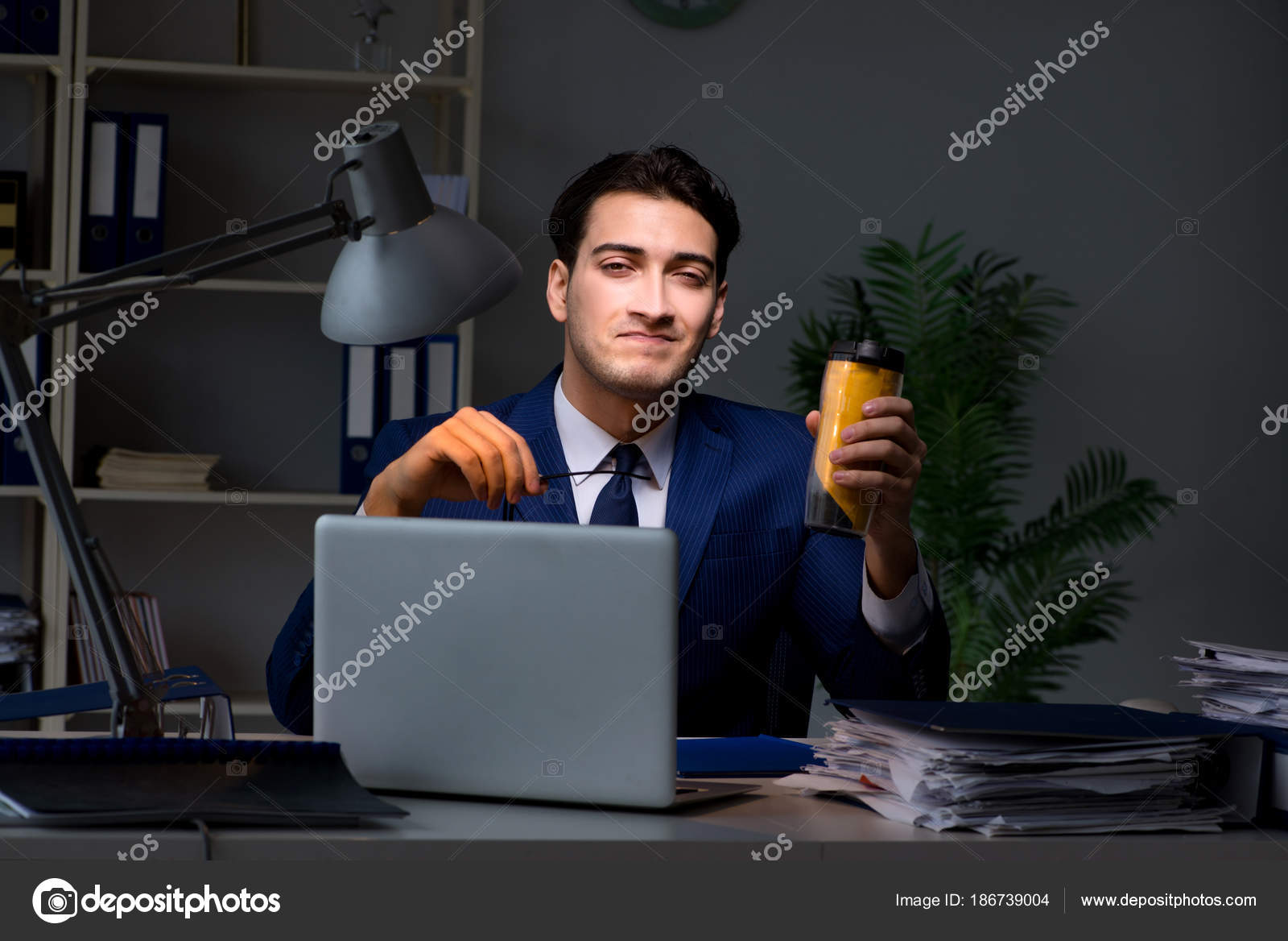 Employee Working Late And Drinking Strong Coffee To Stay Awake