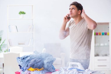 Dikkatsiz koca ütü yaparken giysilerini yakıyor.