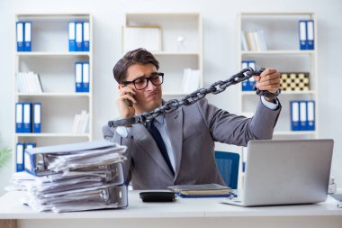 Ofis masasına zincirlenmiş meşgul bir çalışan.