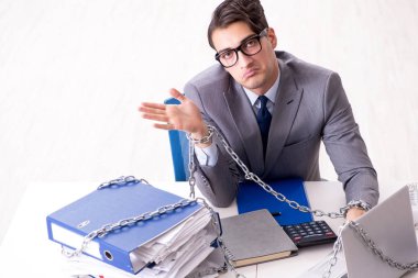 Ofis masasına zincirlenmiş meşgul bir çalışan.