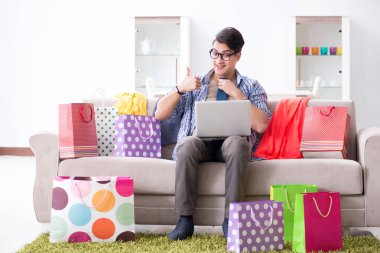 Genç adam internetten kıyafet alıyor ve blog yönetiyor.