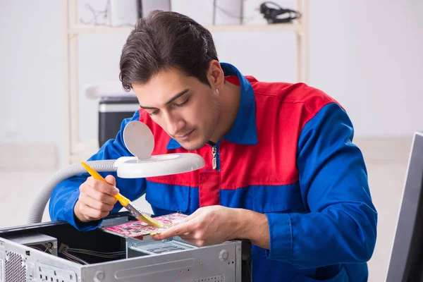 Professional repairman repairing computer in workshop