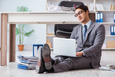 İş adamı ofiste çalışıyor ve oturuyor.