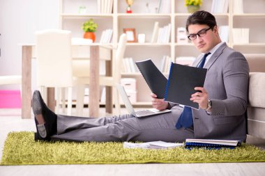 İş adamı evde yerde çalışıyor.