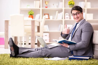 İş adamı evde yerde çalışıyor.