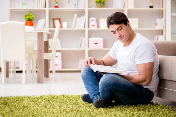 Hombre leyendo libro en casa en el suelo — Foto de Stock