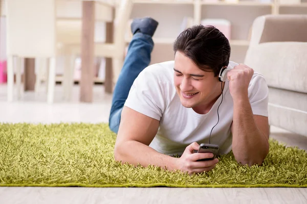 Joven estudiante escuchando música en casa — Foto de Stock