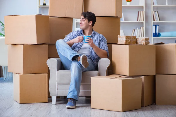 Young man moving in to new house with boxes — Stock Photo, Image