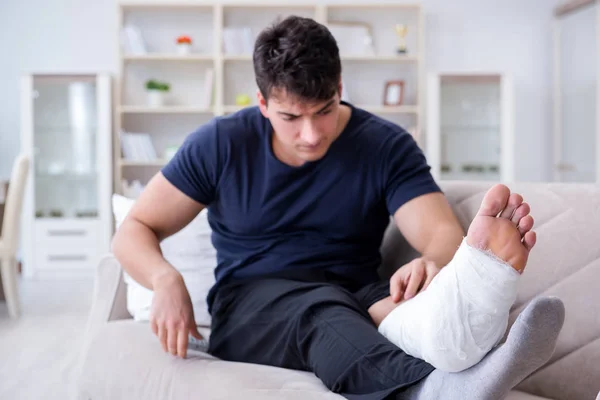 Hombre con la pierna rota recuperándose en casa —  Fotos de Stock