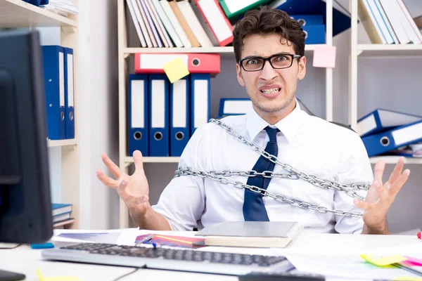 Anställd fäst och fastkedjad vid sitt skrivbord med kedja — Stockfoto