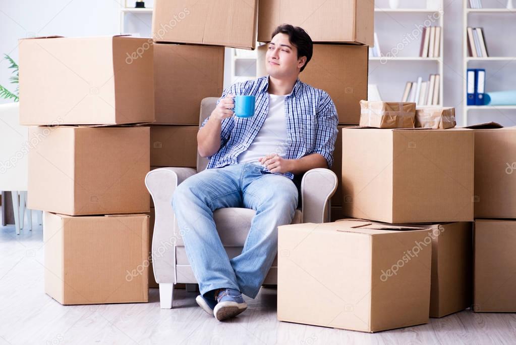 Young man moving in to new house with boxes