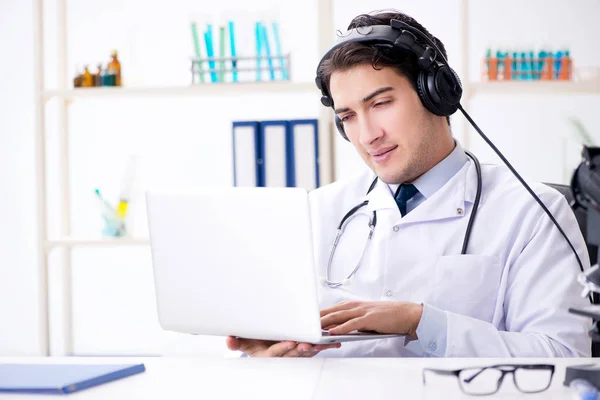 Männlicher Arzt hört Patientin während telemedizinischer Sitzung zu — Stockfoto