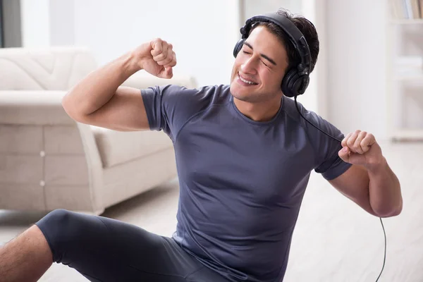 Adam evde spor yapıyor ve müzik dinliyor. — Stok fotoğraf