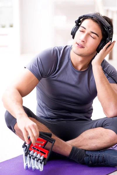 Hombre haciendo deportes con banda de resistencia y escuchando música —  Fotos de Stock