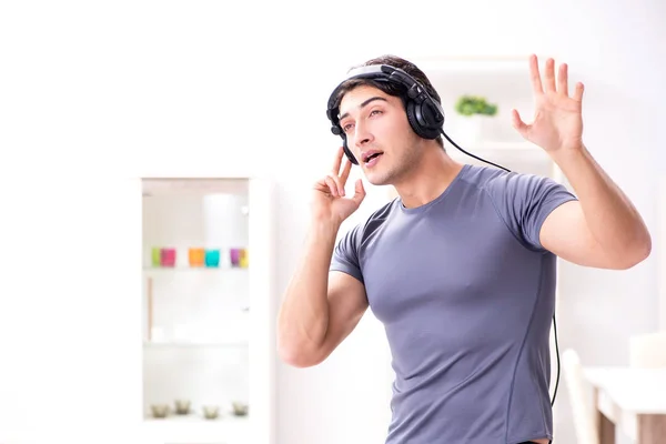 Hombre haciendo deportes en casa y escuchando música —  Fotos de Stock