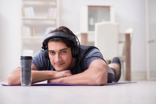 Man idrottar hemma och lyssnar på musik — Stockfoto