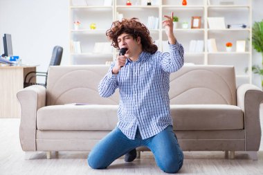 Evde karaoke yapan komik adam.