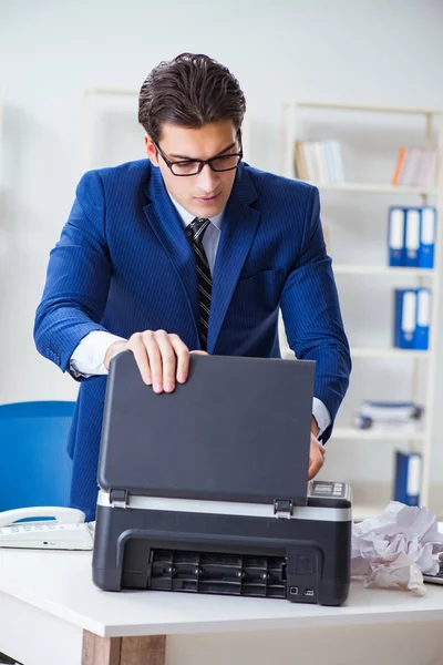 Businessman angry at copying machine jamming papers — Stock Photo, Image